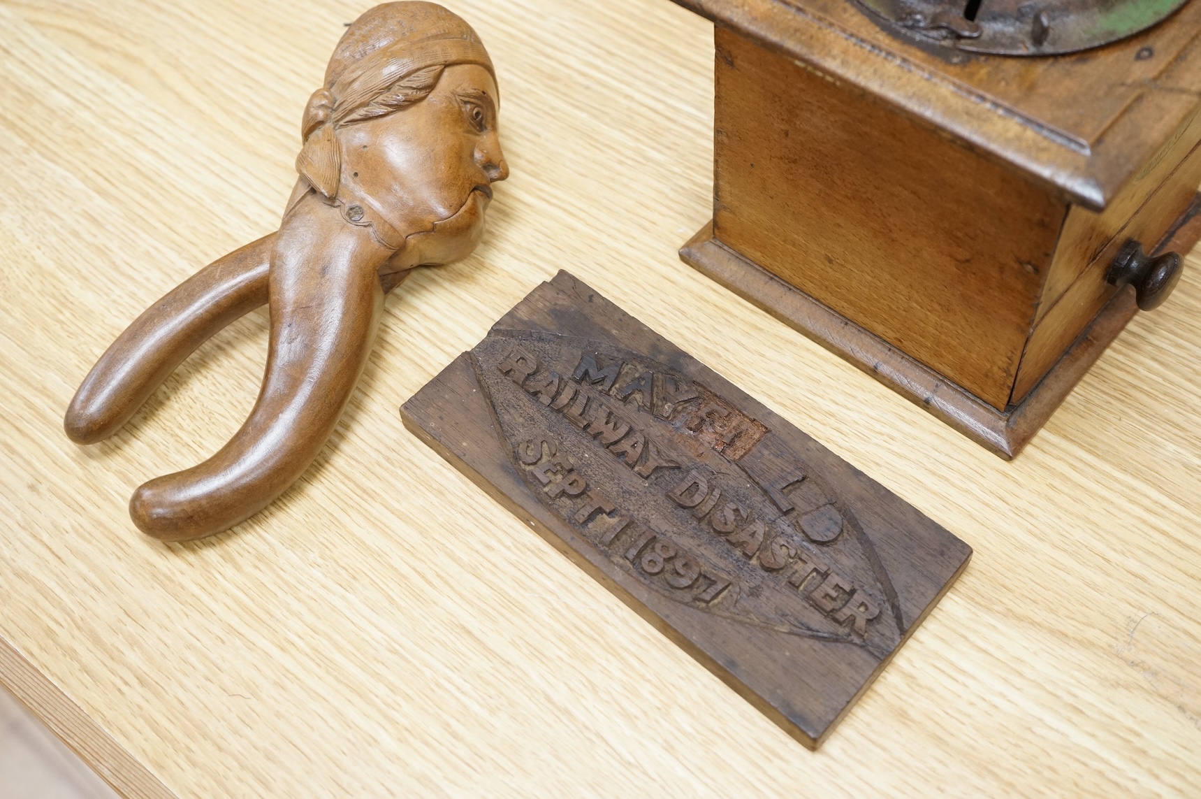 A coffee grinder, a figural nut cracker, two walking sticks, one mother of pearl inlaid and a railway sign